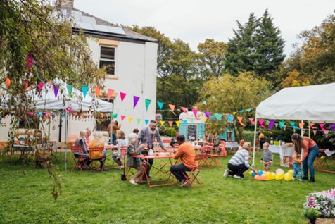 A group of people sitting at tables in a yard